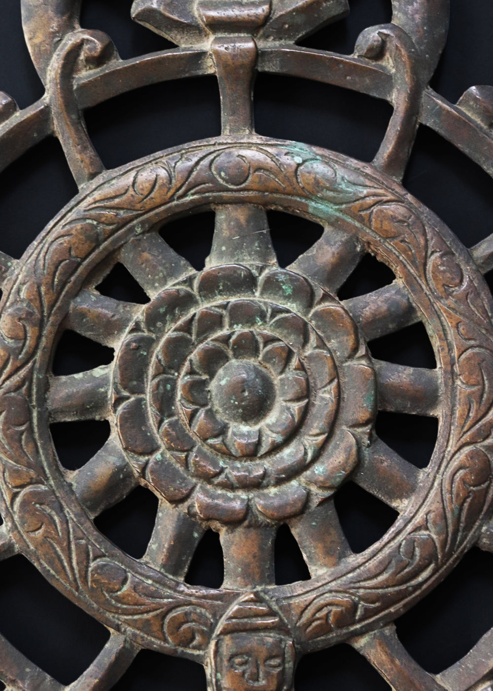 Antique cast bronze dharmachakra with a central lotus rosette within the spoked wheel