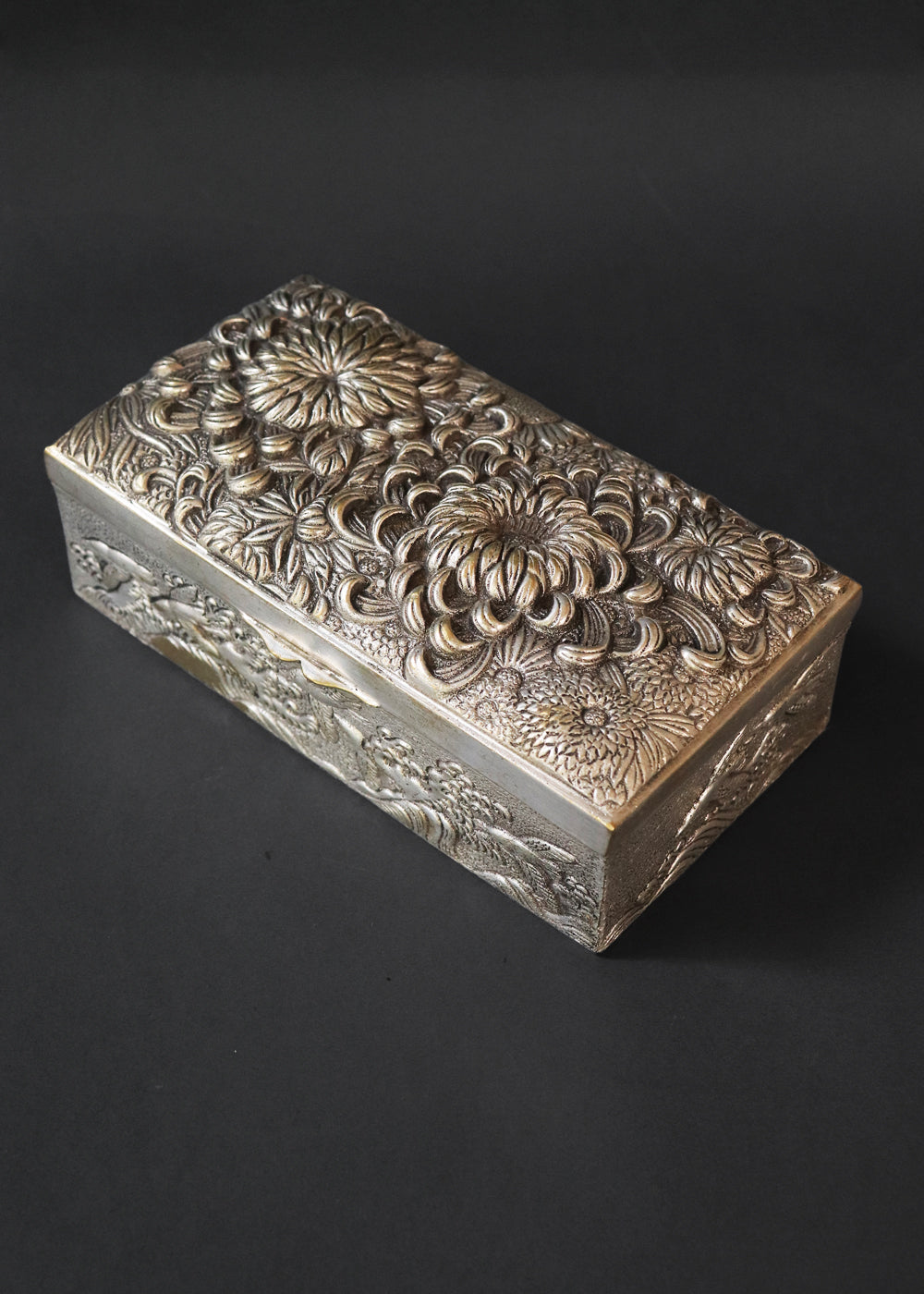 Meiji period Japanese box with very beautifully detailed chrysanthemums “kiku” in high relief and almost life-like petals. In Japan, the chrysanthemum is very cherished as a symbol of the imperial house, and the term “chrysanthemum throne” refers both to the actual throne as well as the emperor himself. Every year the 'Festival of Happiness' is celebrated in honour of the chrysanthemum. The side panels of the box depict birds in stormy seas with waves in the style of The Great Wave by Hokusai, all in relief