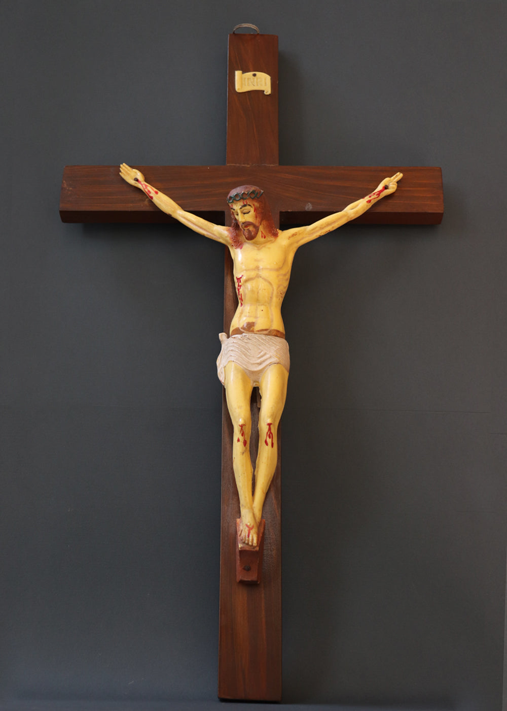 Vintage crucifix with Jesus probably made out of celluloid which is a form of early plastics. The moulded celluloid has been painted with details and the cross carries the traditional INRI plaque at the top. These lighter pieces were made to be a part of home altars, and should be from between the 1950s-1920s, India.
