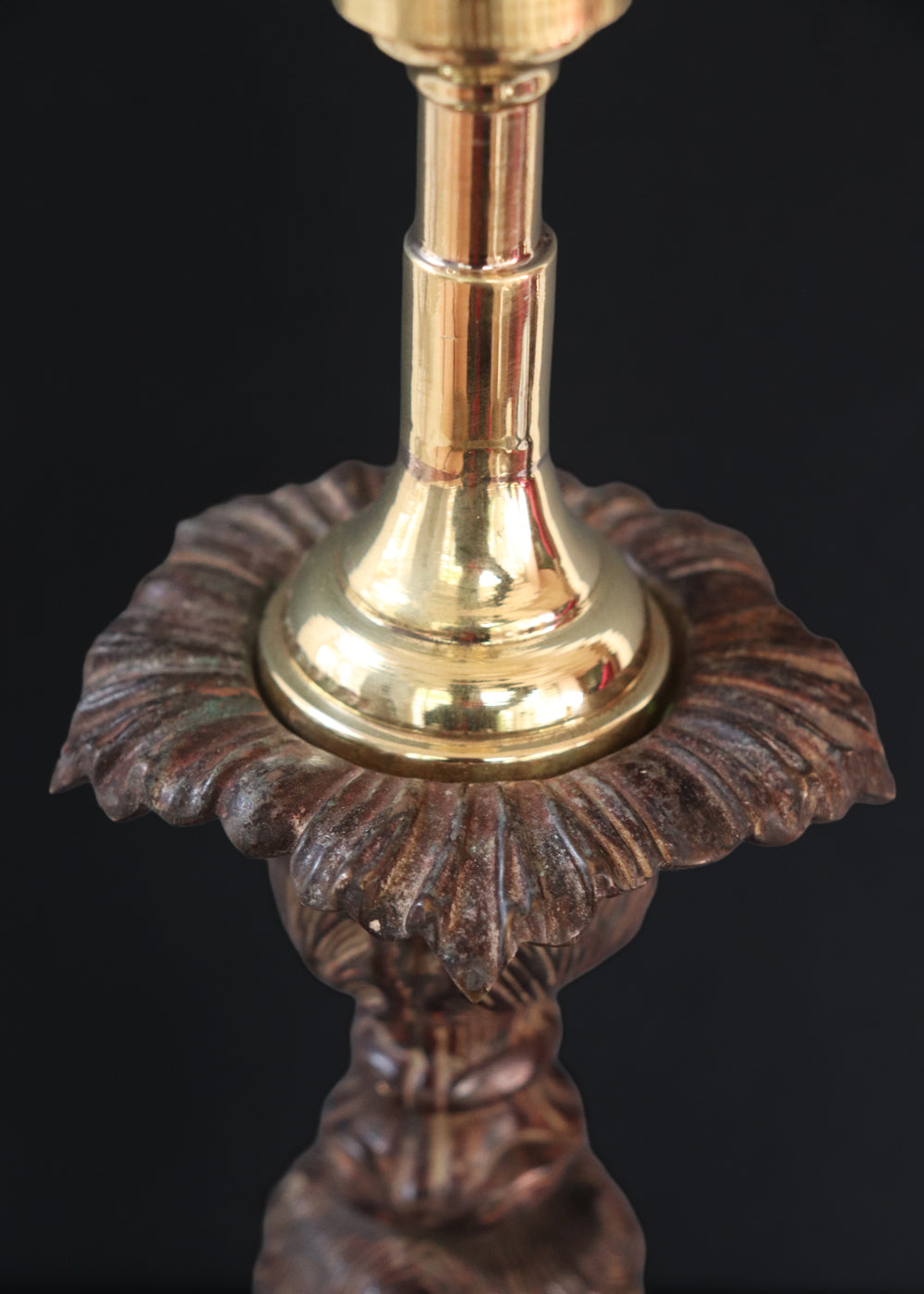 Unusually large bronze candle stick in neoclassical design. The column ends in a beautiful bud shape, and the knop and sconce are all covered in anacthus leaves. The raised round base has an alternating pattern of a spray of leaves and drops.. The sconce opens up into a beautiful flower. The sconce and the base has a conduit for a wire to be passed through so that this candle stand can be converted into a lamp as well. Should be from the mid 1900s, England.