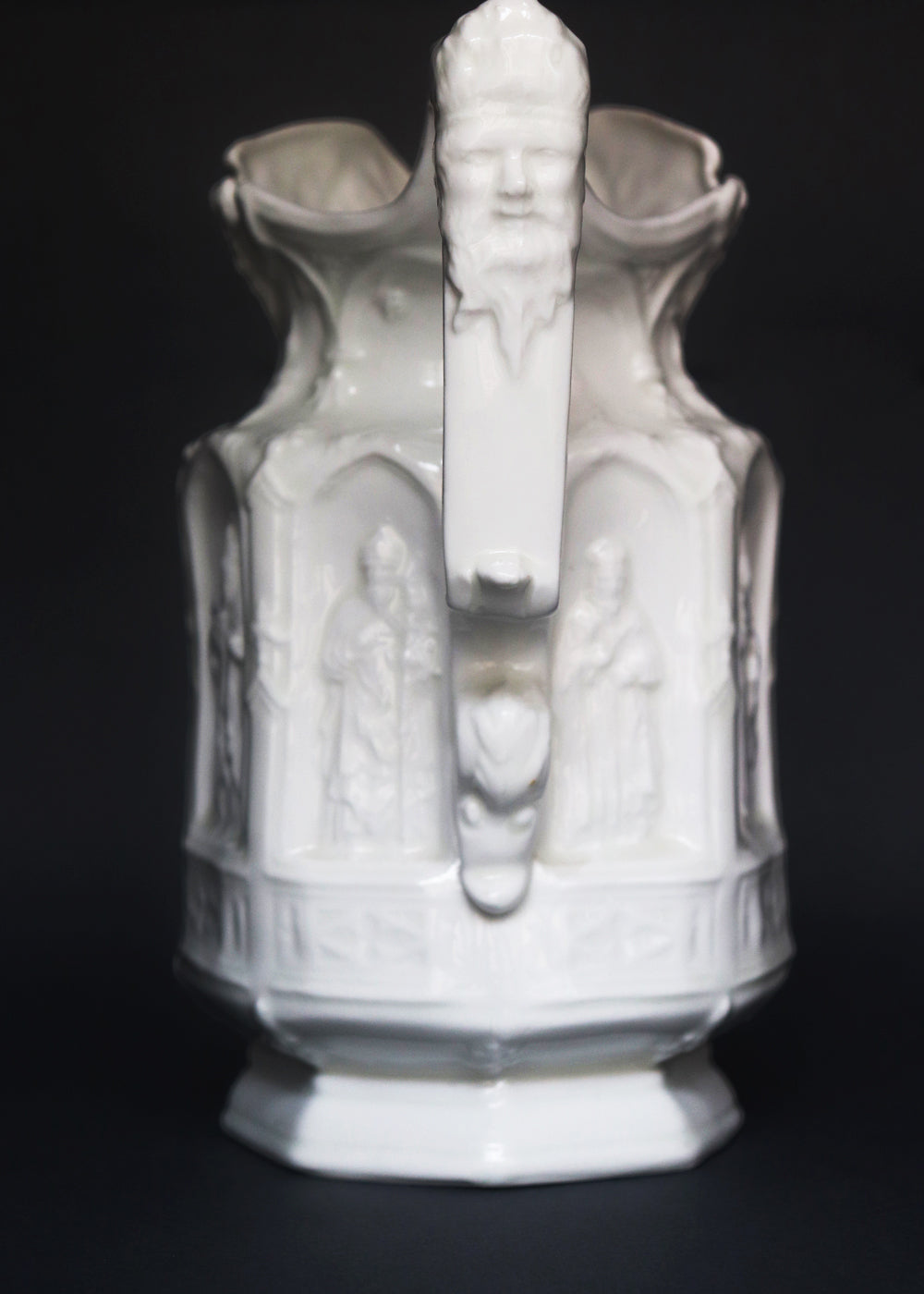 Vintage Apostle Jug featuring raised, molded figures of the apostles under Gothic-style architectural arches. This design was first made by Charles Meigh in 1842 in Staffordshire, and these pieces are displayed at the V&A and the Metropolitan Museum. The arcaded "Gothic" decoration is a response by the pottery industry to the ideas of the influential architect and designer Augustus Charles Pugin (1762–1832). The design was so popular that several companies continued making them more than a 100 years aft