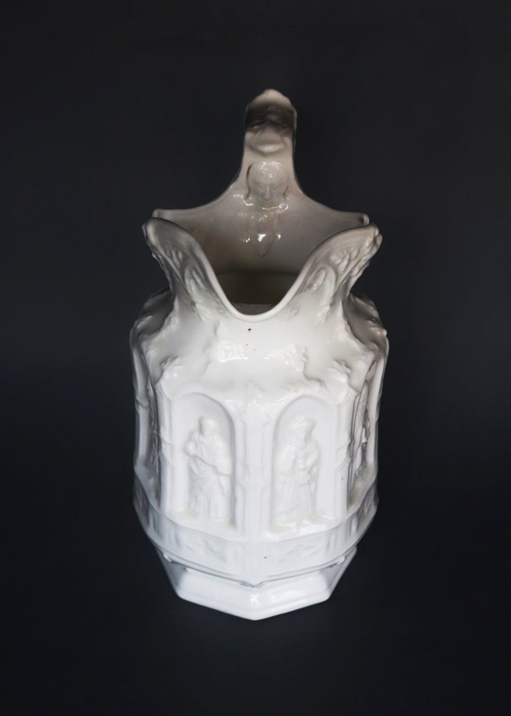 Vintage Apostle Jug featuring raised, molded figures of the apostles under Gothic-style architectural arches. This design was first made by Charles Meigh in 1842 in Staffordshire, and these pieces are displayed at the V&A and the Metropolitan Museum. The arcaded "Gothic" decoration is a response by the pottery industry to the ideas of the influential architect and designer Augustus Charles Pugin (1762–1832). The design was so popular that several companies continued making them more than a 100 years aft