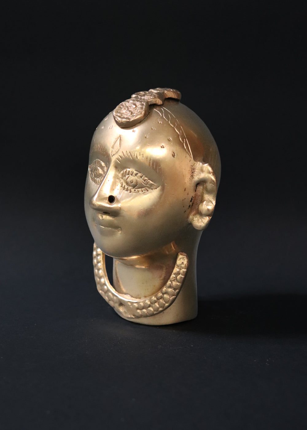 Vintage Brass Gauri head, the divine embodiment of Shakti, the Mother Goddess, the benevolent form of Parvati. She is highly bejewelled with a neckpiece, head and ear ornaments. The nose has a provision to adorn it with a nose ring. The piece has ben recently polished, and is in great condition From the mid 1900s India.