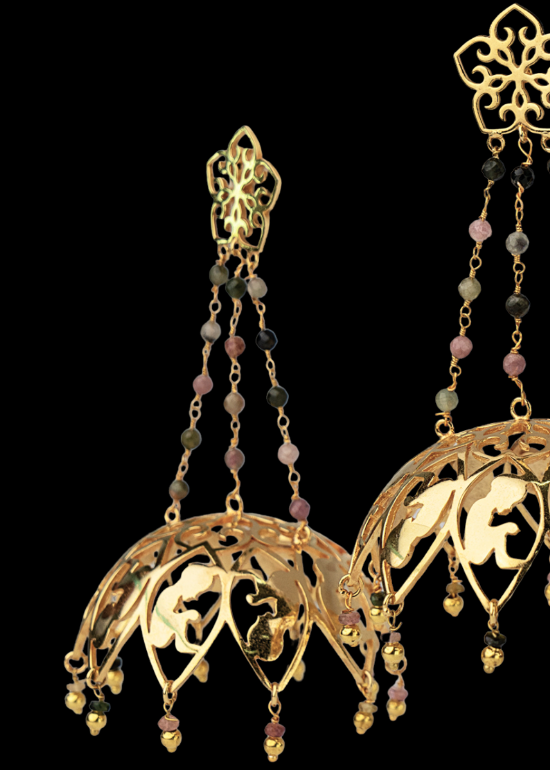 Gold jhumka earrings with intricate designs and tourmaline embellishments for parties and occasion wear