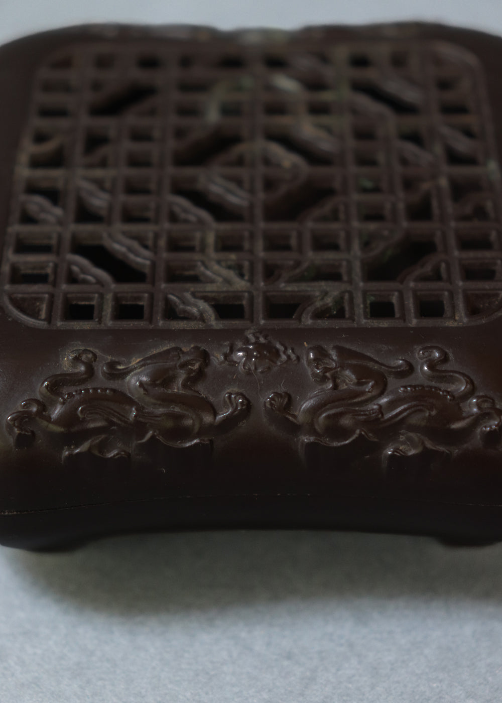 Late Qing dynasty bronze censer with a beautiful open lattice work lid. It has double dragon motifs on two sides, symboling good fortune and protection. The lattice allows fragrant smoke to curl up gently through the pattern. The censer has soft rounded edges, and the base has a four-character seal mark that reads "Qianlong Nian Zhi”, or Made during the Qianlong period. This would most likely be an early 1900s piece, made in China.