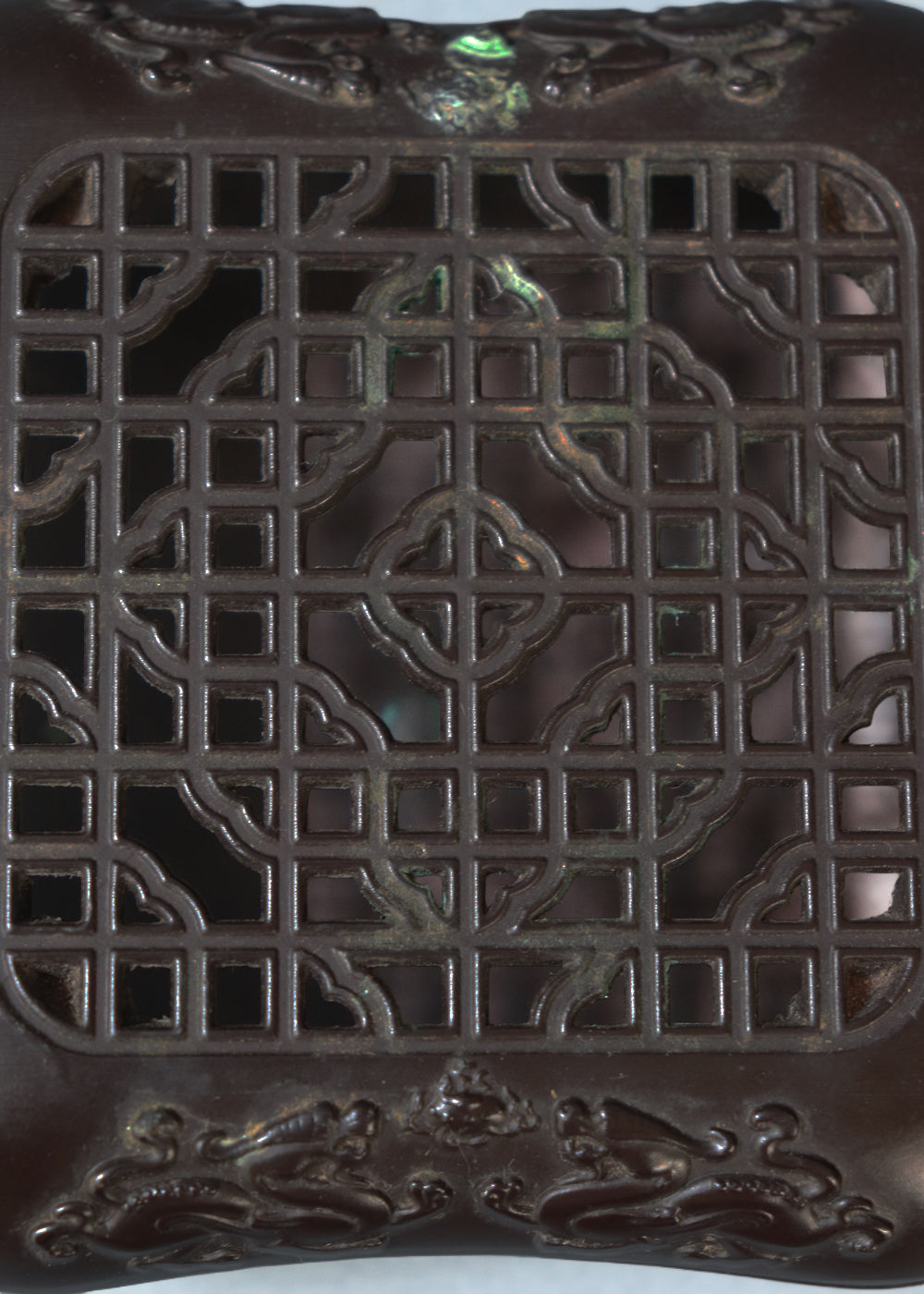 Late Qing dynasty bronze censer with a beautiful open lattice work lid. It has double dragon motifs on two sides, symboling good fortune and protection. The lattice allows fragrant smoke to curl up gently through the pattern. The censer has soft rounded edges, and the base has a four-character seal mark that reads "Qianlong Nian Zhi”, or Made during the Qianlong period. This would most likely be an early 1900s piece, made in China.