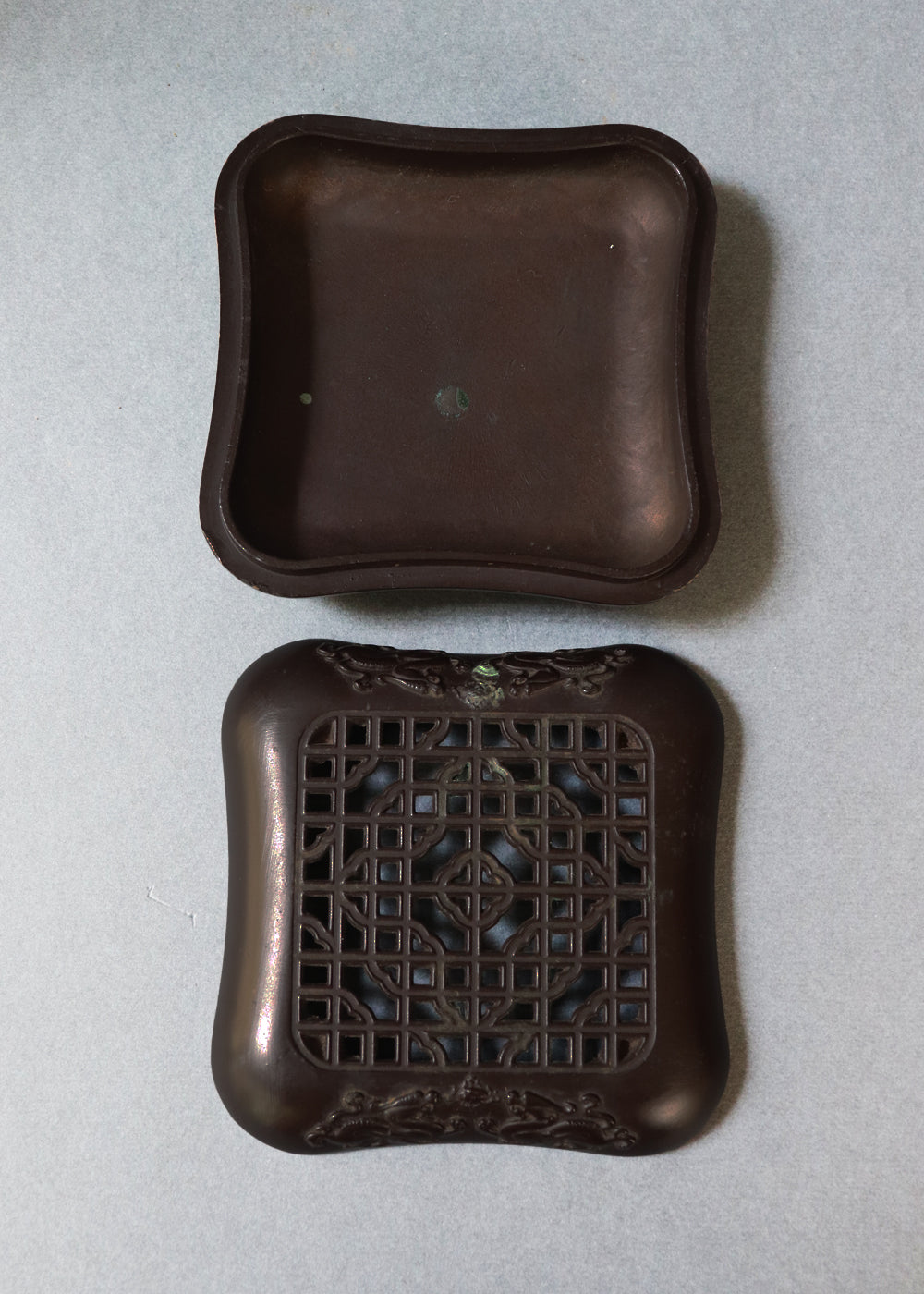 Late Qing dynasty bronze censer with a beautiful open lattice work lid. It has double dragon motifs on two sides, symboling good fortune and protection. The lattice allows fragrant smoke to curl up gently through the pattern. The censer has soft rounded edges, and the base has a four-character seal mark that reads "Qianlong Nian Zhi”, or Made during the Qianlong period. This would most likely be an early 1900s piece, made in China.