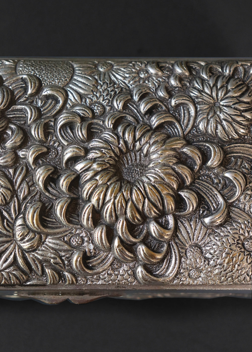 Meiji period Japanese box with very beautifully detailed chrysanthemums “kiku” in high relief and almost life-like petals. In Japan, the chrysanthemum is very cherished as a symbol of the imperial house, and the term “chrysanthemum throne” refers both to the actual throne as well as the emperor himself. Every year the 'Festival of Happiness' is celebrated in honour of the chrysanthemum. The side panels of the box depict birds in stormy seas with waves in the style of The Great Wave by Hokusai, all in relief