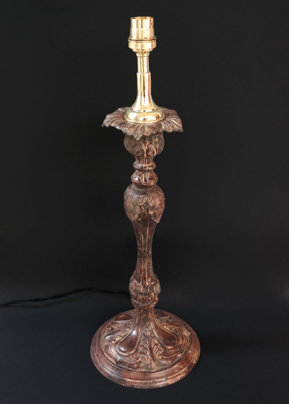 Unusually large bronze candle stick in neoclassical design. The column ends in a beautiful bud shape, and the knop and sconce are all covered in anacthus leaves. The raised round base has an alternating pattern of a spray of leaves and drops.. The sconce opens up into a beautiful flower. The sconce and the base has a conduit for a wire to be passed through so that this candle stand can be converted into a lamp as well. Should be from the mid 1900s, England.