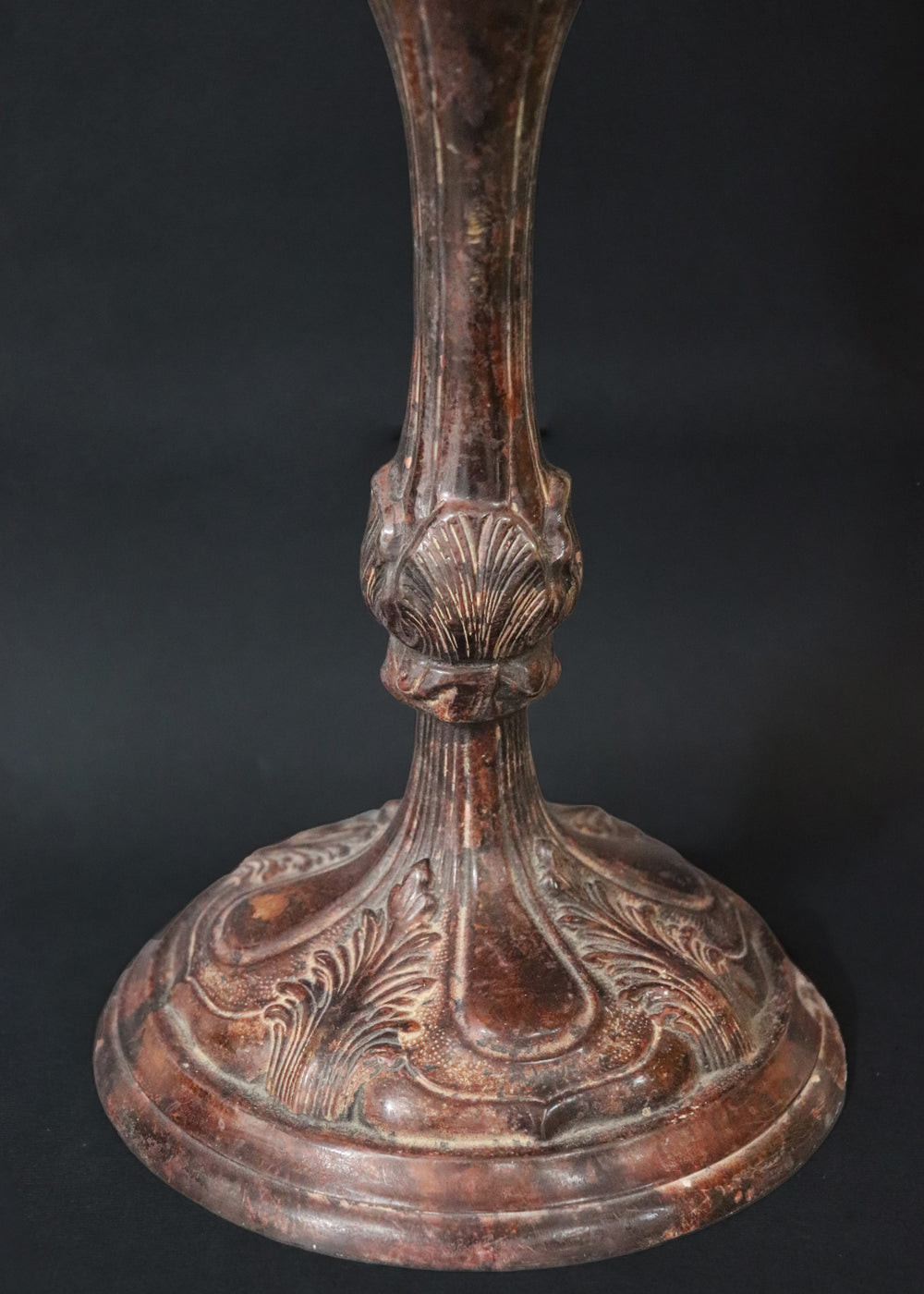 Unusually large bronze candle stick in neoclassical design. The column ends in a beautiful bud shape, and the knop and sconce are all covered in anacthus leaves. The raised round base has an alternating pattern of a spray of leaves and drops.. The sconce opens up into a beautiful flower. The sconce and the base has a conduit for a wire to be passed through so that this candle stand can be converted into a lamp as well. Should be from the mid 1900s, England.