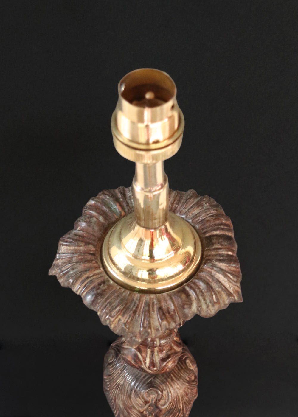 Unusually large bronze candle stick in neoclassical design. The column ends in a beautiful bud shape, and the knop and sconce are all covered in anacthus leaves. The raised round base has an alternating pattern of a spray of leaves and drops.. The sconce opens up into a beautiful flower. The sconce and the base has a conduit for a wire to be passed through so that this candle stand can be converted into a lamp as well. Should be from the mid 1900s, England.