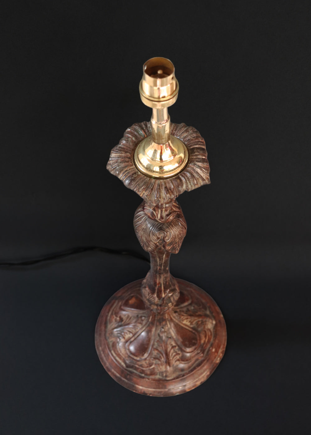 Unusually large bronze candle stick in neoclassical design. The column ends in a beautiful bud shape, and the knop and sconce are all covered in anacthus leaves. The raised round base has an alternating pattern of a spray of leaves and drops.. The sconce opens up into a beautiful flower. The sconce and the base has a conduit for a wire to be passed through so that this candle stand can be converted into a lamp as well. Should be from the mid 1900s, England.
