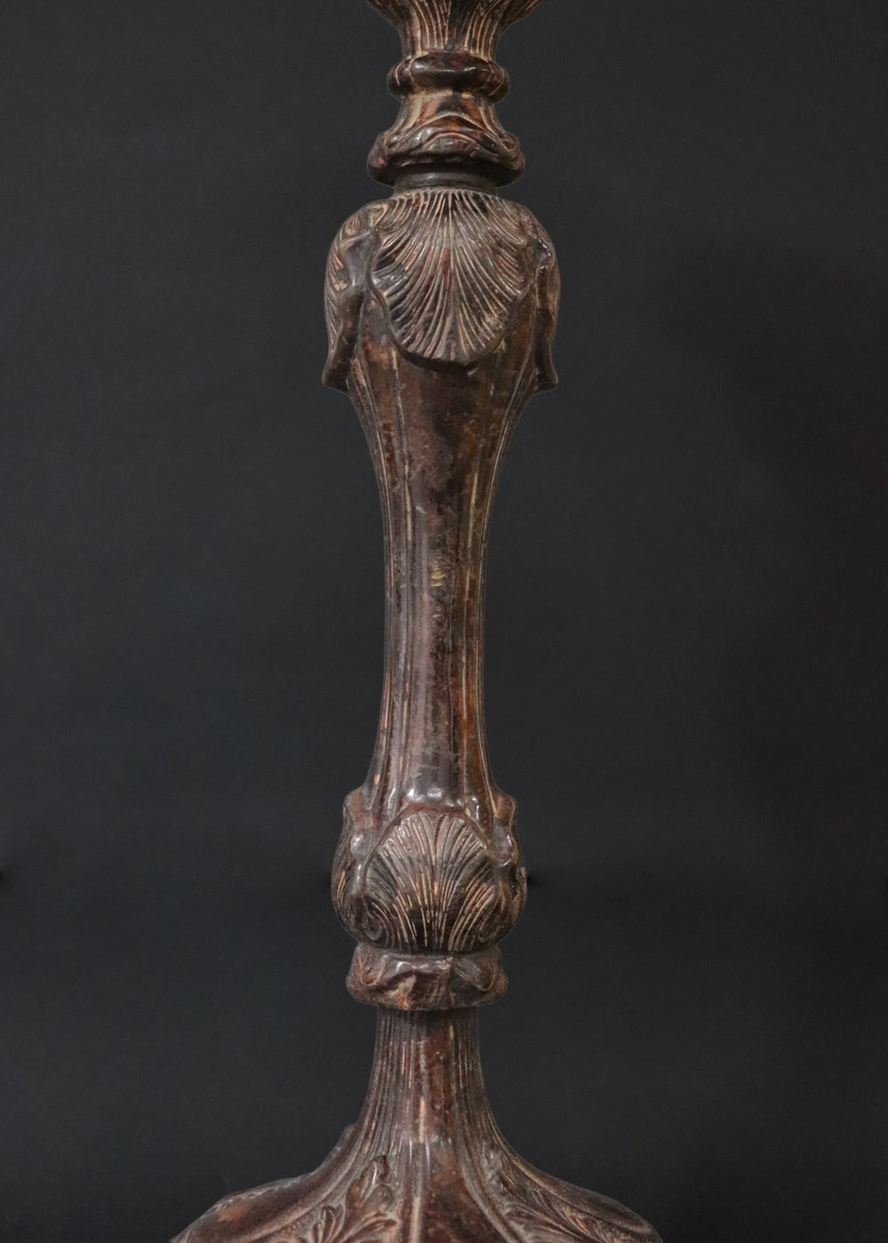 Unusually large bronze candle stick in neoclassical design. The column ends in a beautiful bud shape, and the knop and sconce are all covered in anacthus leaves. The raised round base has an alternating pattern of a spray of leaves and drops.. The sconce opens up into a beautiful flower. The sconce and the base has a conduit for a wire to be passed through so that this candle stand can be converted into a lamp as well. Should be from the mid 1900s, England.
