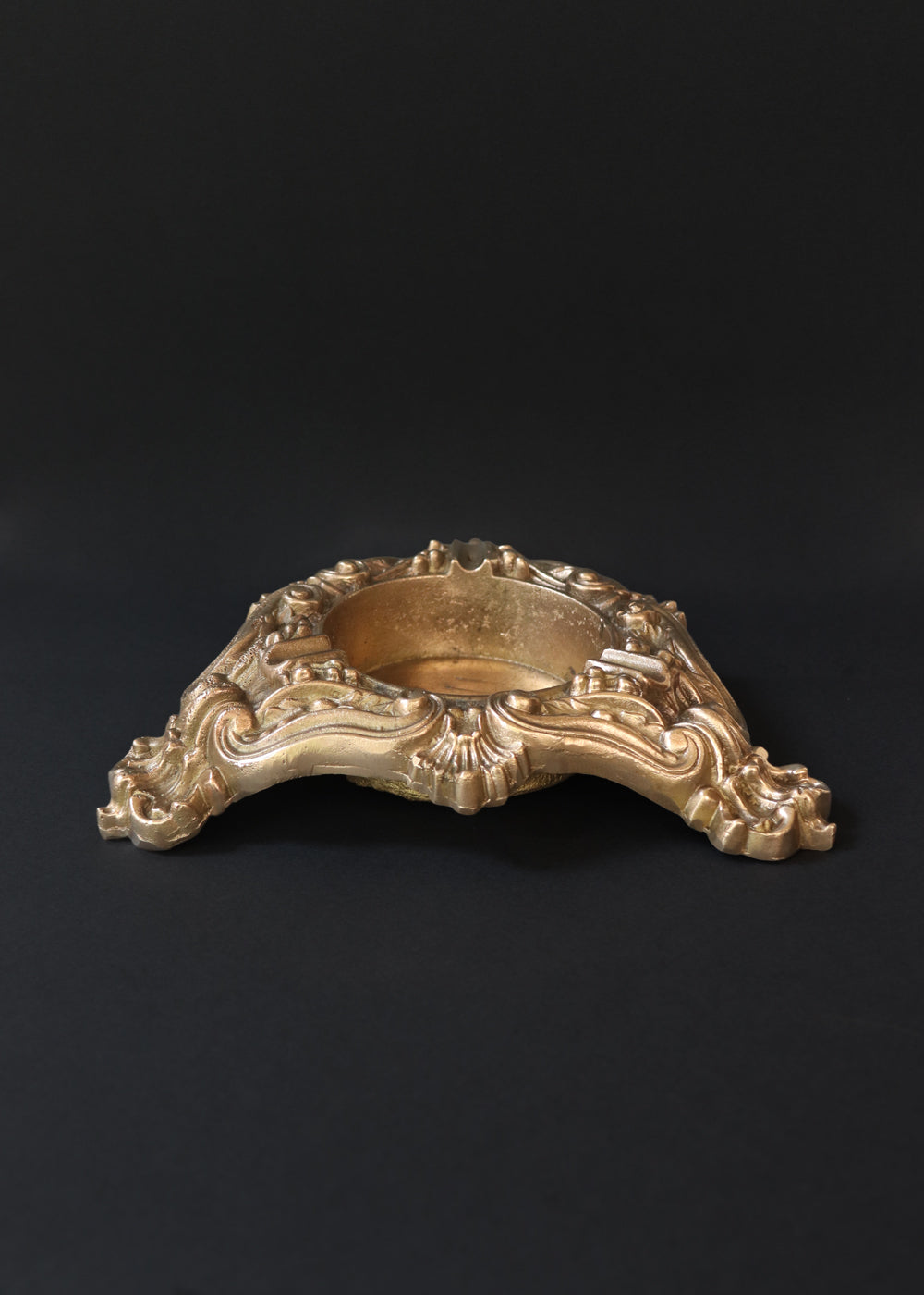 Vintage heavy cast brass ashtray is almost 2 kg in weight. The triangular body is ornamented in Baroque style with elaborate scrollwork, floral reliefs, acanthus leaves and rocaille shells. It has three integrated cigarette rests and a central bowl for the Ash. Should be from the mid 1900s, France.