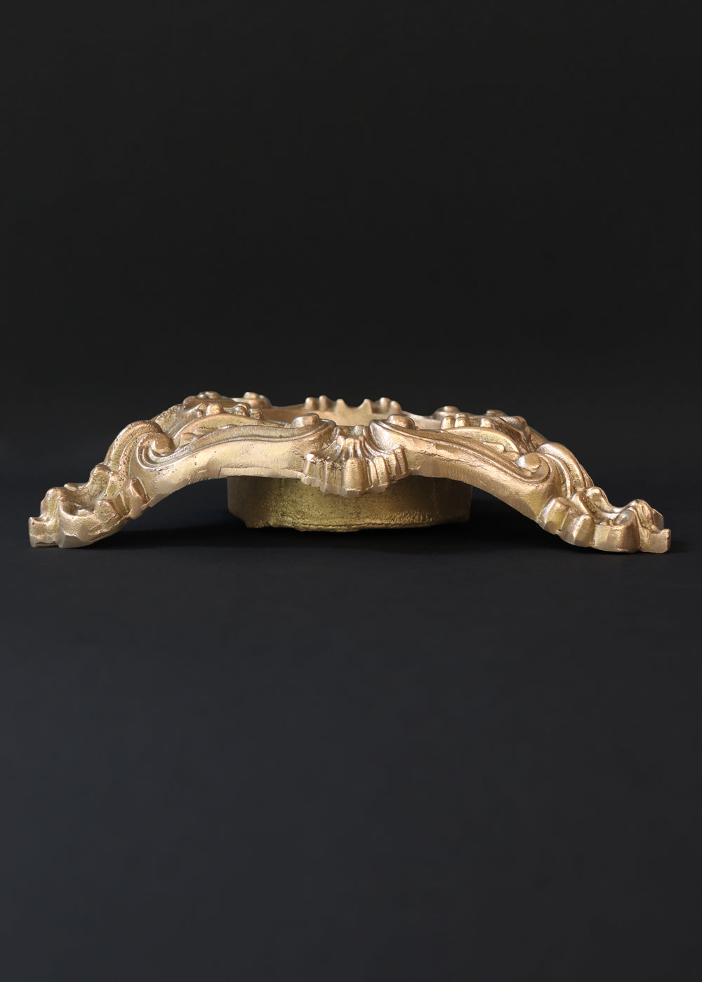 Vintage heavy cast brass ashtray is almost 2 kg in weight. The triangular body is ornamented in Baroque style with elaborate scrollwork, floral reliefs, acanthus leaves and rocaille shells. It has three integrated cigarette rests and a central bowl for the Ash. Should be from the mid 1900s, France.