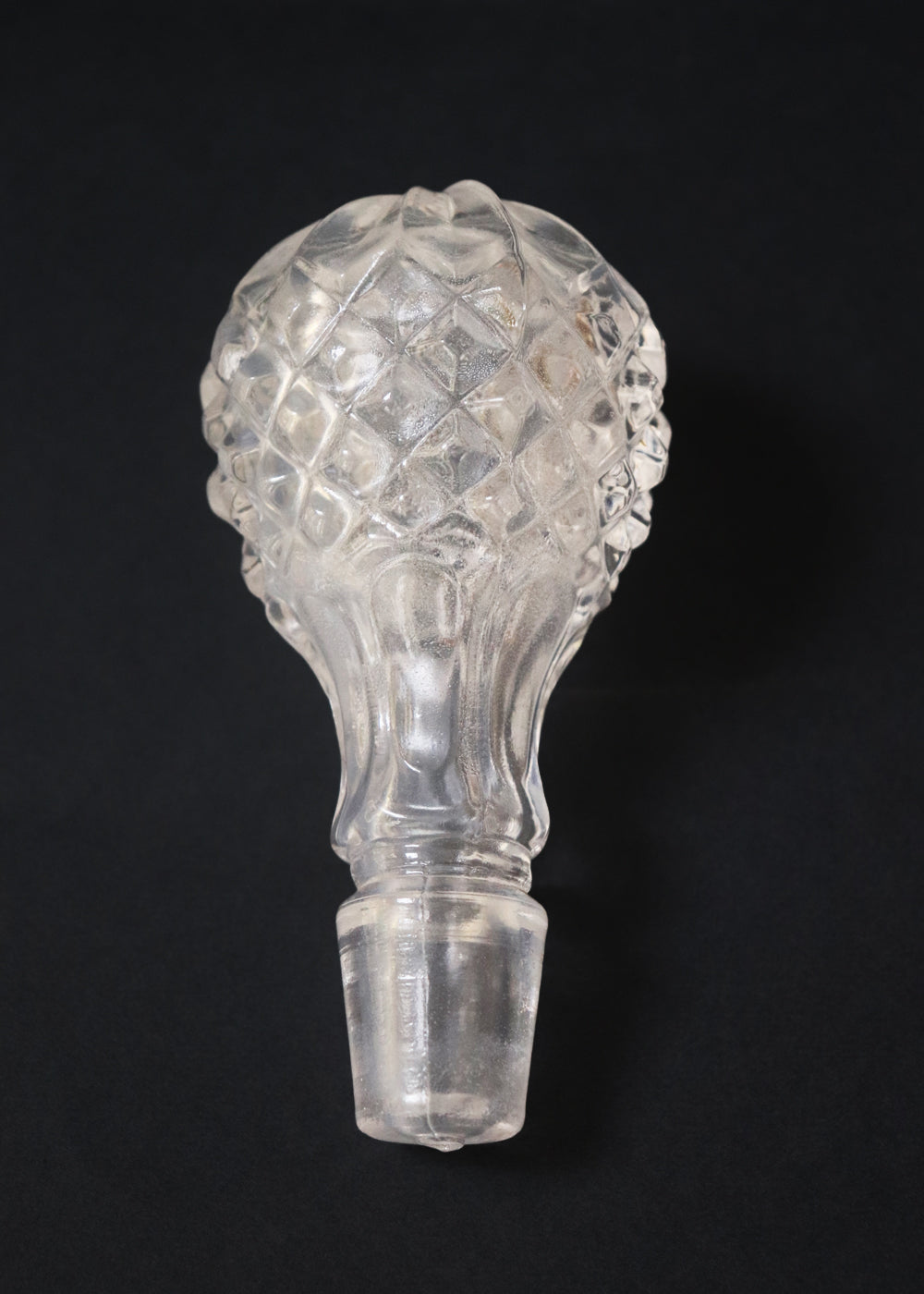 Vintage heavy cut glass decanter most likely meant for port wine. The bell shaped body is deeply facetted with patterns and has etched flowers around it. A diamond patterned ball shaped stopper sits atop the narrow neck. The crystal is somewhat cloudy but otherwise the decanter is in perfect condition. Should be from the mid 1900s, and most likely made in America.