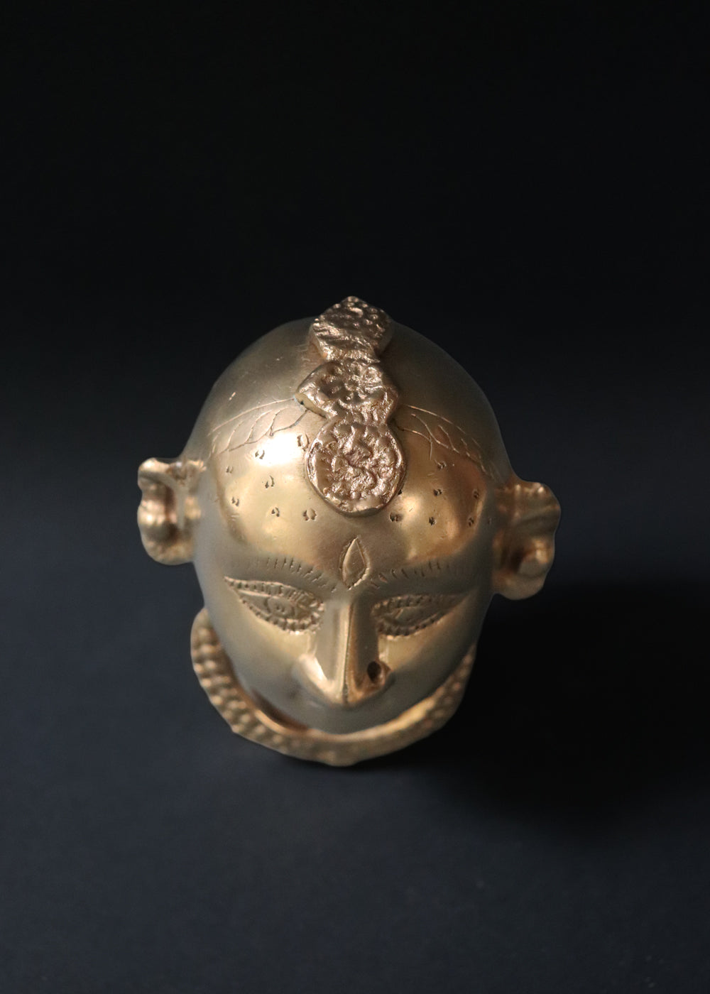 Vintage Brass Gauri head, the divine embodiment of Shakti, the Mother Goddess, the benevolent form of Parvati. She is highly bejewelled with a neckpiece, head and ear ornaments. The nose has a provision to adorn it with a nose ring. The piece has ben recently polished, and is in great condition From the mid 1900s India.