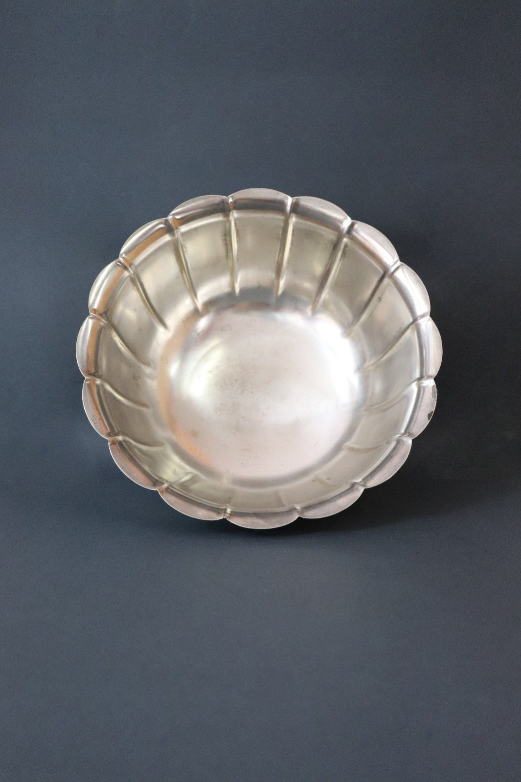 Vintage silver plated Rose Bowl with a classic lobed body and a scalloped undulating rim. The panels sweep upward to form an elegant petaled shape and it is raised on a stepped round pedestal base. It has the markings Sheffield England and a brand name that’s hard to read on the base. It would make a gorgeous centrepiece on dining or console table. Should be from the mid 1900s, England.