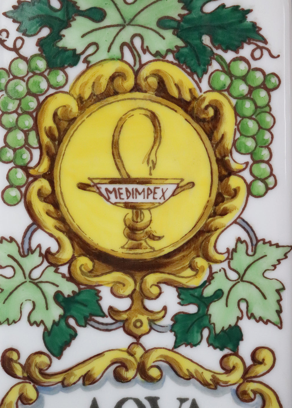 Vintage collectible Hollóházi porcelain bottle specially designed for "Aqua Vitae," which is an old Latin term for "water of life" typically referring to early distilled spirits. Medimpex, who’s name is on a medallion framed with scrolls was a well-known Hungarian/Eastern European pharmaceutical and medical distribution company. The bottle features a green and gold grapevine motifs framing a cartouche with the words "AQVA VITAE" boldly painted in the center. The wooden stopper is in perfect condition. Holló