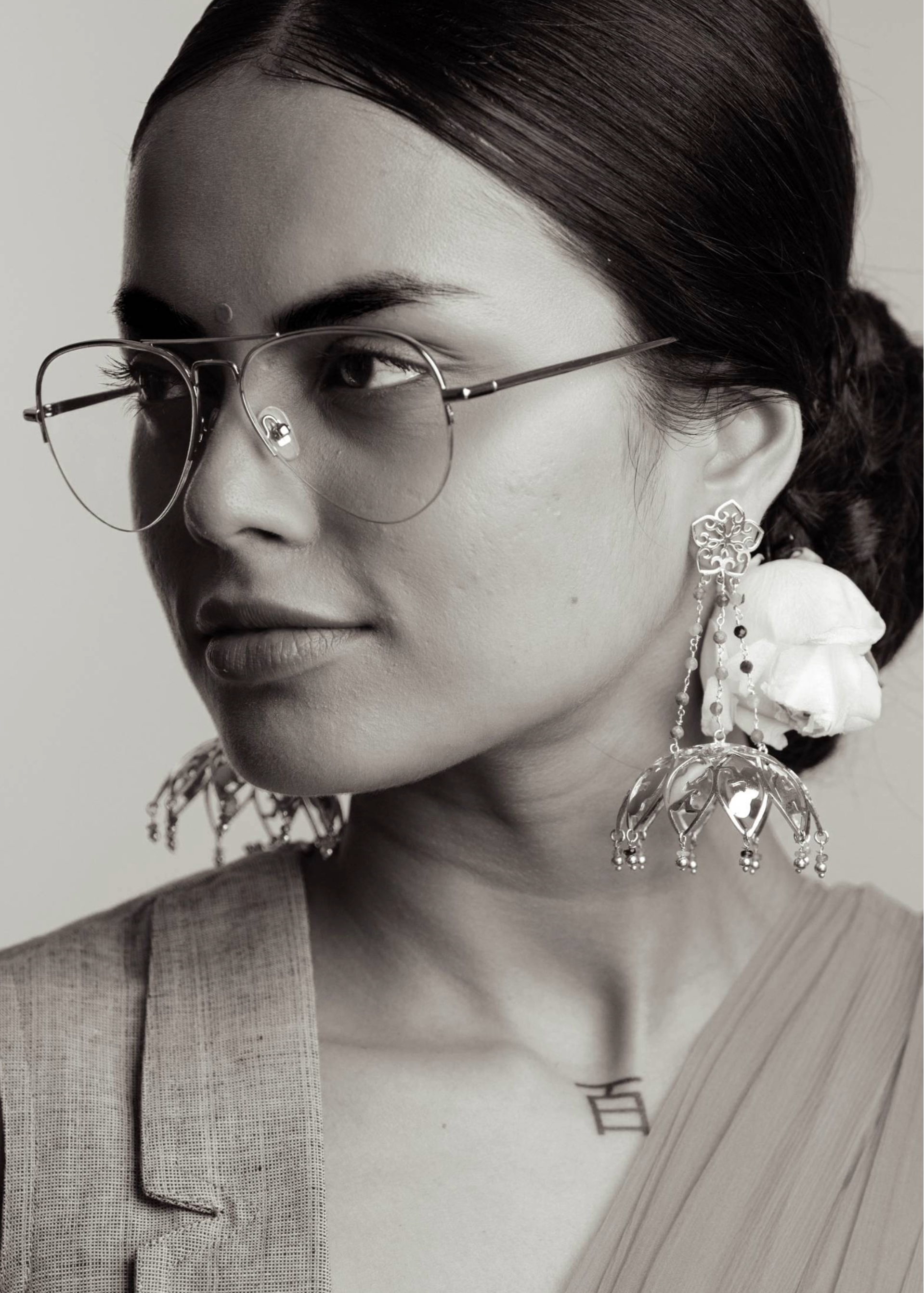 Woman wearing large jhumka earrings with floral details and with tourmalines