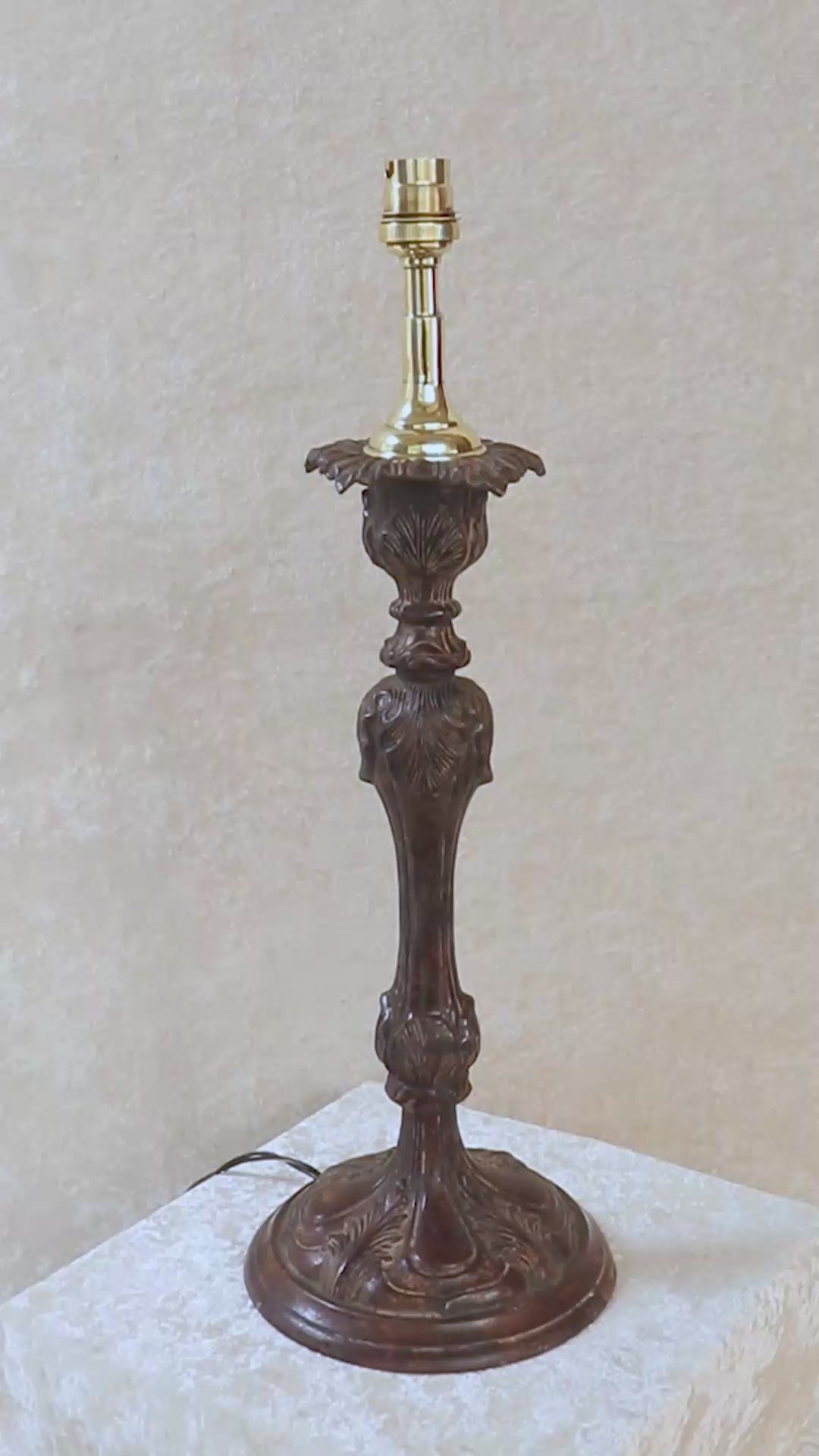 Unusually large vintage bronze candle stick in neoclassical design. The column ends in a beautiful bud shape, and the knop and sconce are all covered in anacthus leaves. The raised round base has an alternating pattern of a spray of leaves and drops.. The sconce opens up into a beautiful flower. The sconce and the base has a conduit for a wire to be passed through so that this candle stand can be converted into a lamp as well. Should be from the mid 1900s, England.
