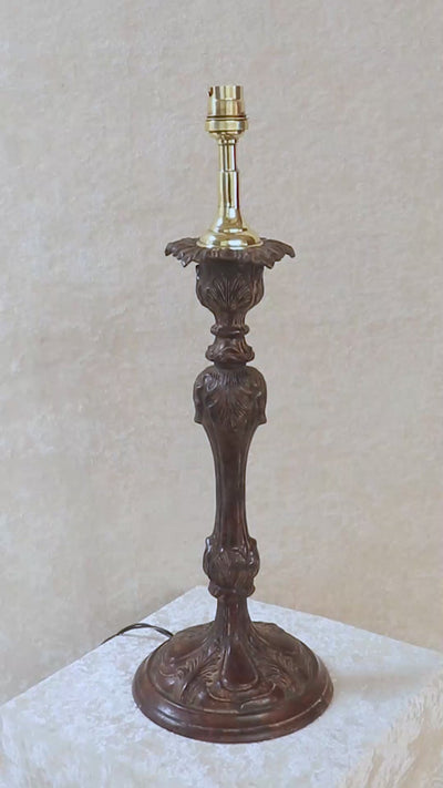Unusually large vintage bronze candle stick in neoclassical design. The column ends in a beautiful bud shape, and the knop and sconce are all covered in anacthus leaves. The raised round base has an alternating pattern of a spray of leaves and drops.. The sconce opens up into a beautiful flower. The sconce and the base has a conduit for a wire to be passed through so that this candle stand can be converted into a lamp as well. Should be from the mid 1900s, England.