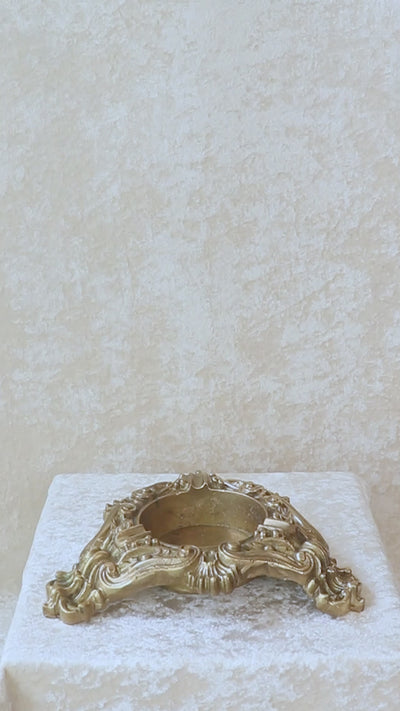 Vintage heavy cast brass ashtray is almost 2 kg in weight. The triangular body is ornamented in Baroque style with elaborate scrollwork, floral reliefs, acanthus leaves and rocaille shells. It has three integrated cigarette rests and a central bowl for the Ash. Should be from the mid 1900s, France.