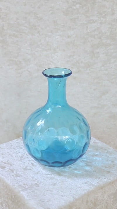 Vintage turquoise blue dimpled glass vase with a onion shaped body. It has a narrow elongated neck which widens out slightly to a rounded rim. The coin, dot or thumbprint pattern on its body is typical of the early to mid 1900s. Can also be used as a decanter.
