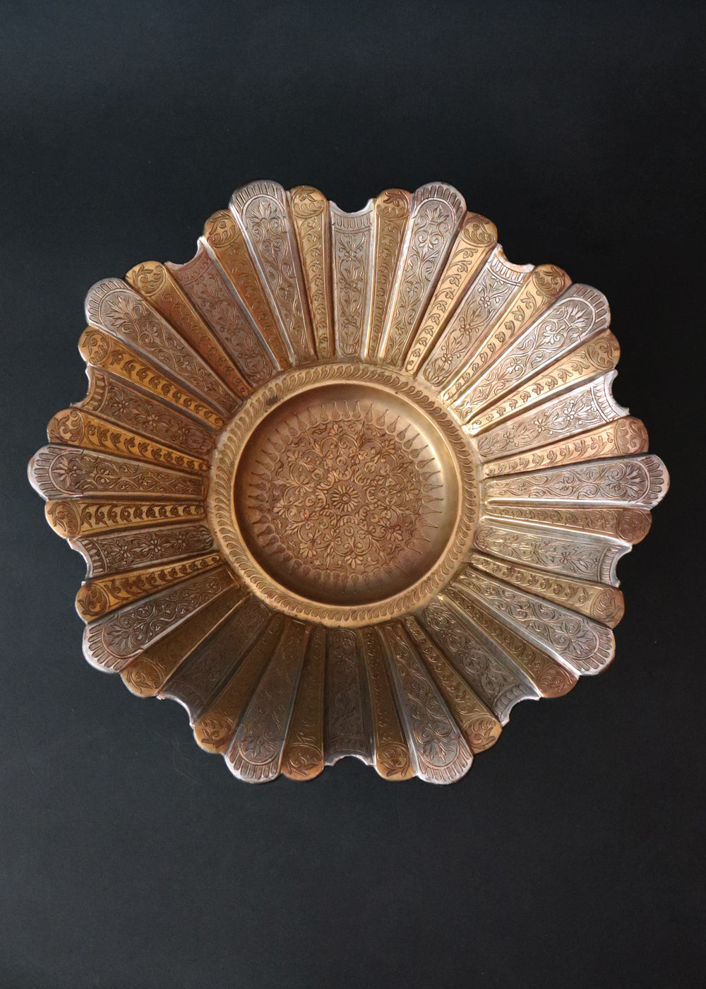 Gorgeous vintage Persian style two-toned fruit bowl in brass. The flower shaped bowl has a scalloped edge and has been constructed with 40 lobed panels at different heights, with alternating gold and silver plating. It is intricately hand-etched throughout. It stands raised on a stepped round base. It would make a beautiful centrepiece for any table. Early to mid 1900s.