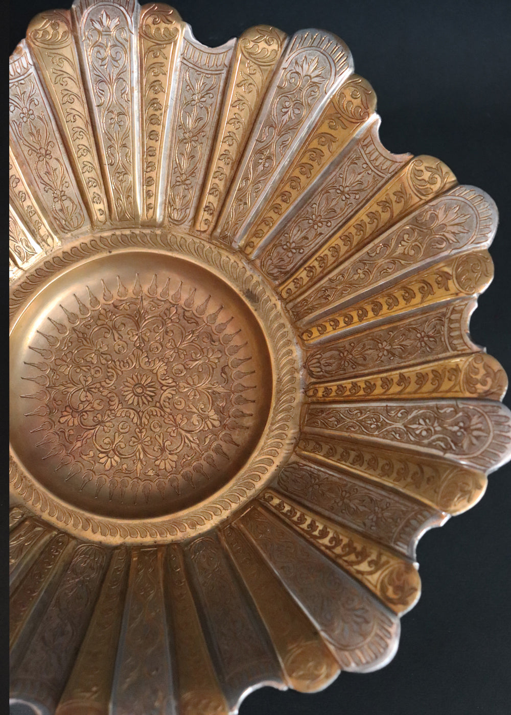 Gorgeous vintage Persian style two-toned fruit bowl in brass. The flower shaped bowl has a scalloped edge and has been constructed with 40 lobed panels at different heights, with alternating gold and silver plating. It is intricately hand-etched throughout. It stands raised on a stepped round base. It would make a beautiful centrepiece for any table. Early to mid 1900s.